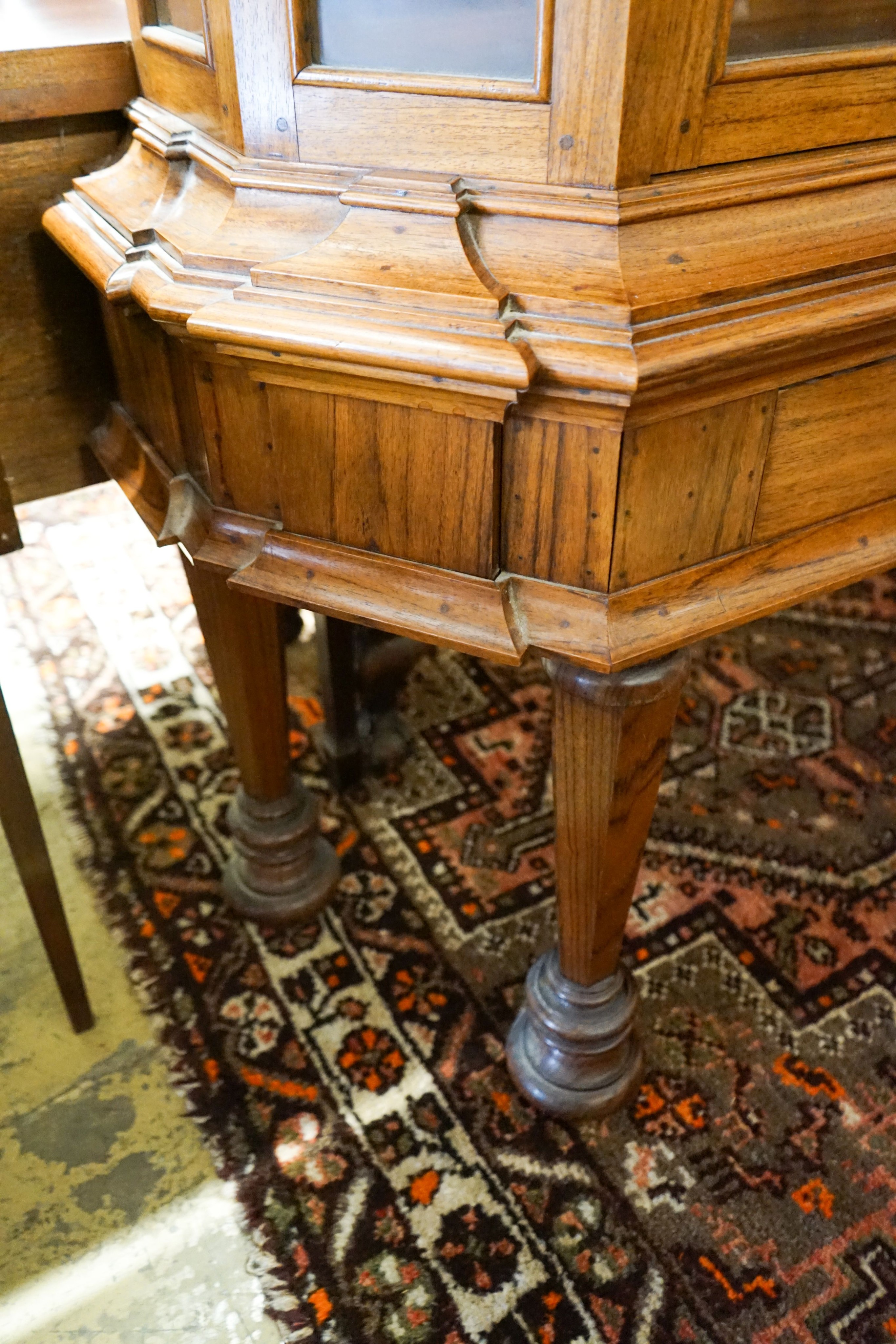 An 18th century style Dutch walnut display case, with double-arched moulded cornice over a pair of astragal-glazed panelled doors, frieze drawer and base with octagonal tapered legs and lion feet, length 132cm, depth 46c